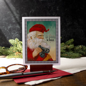 a card with a picture of a santa holding a camera