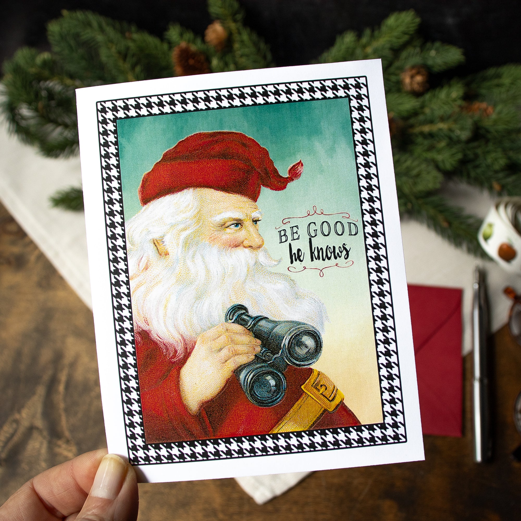 a hand holding up a card with a picture of santa