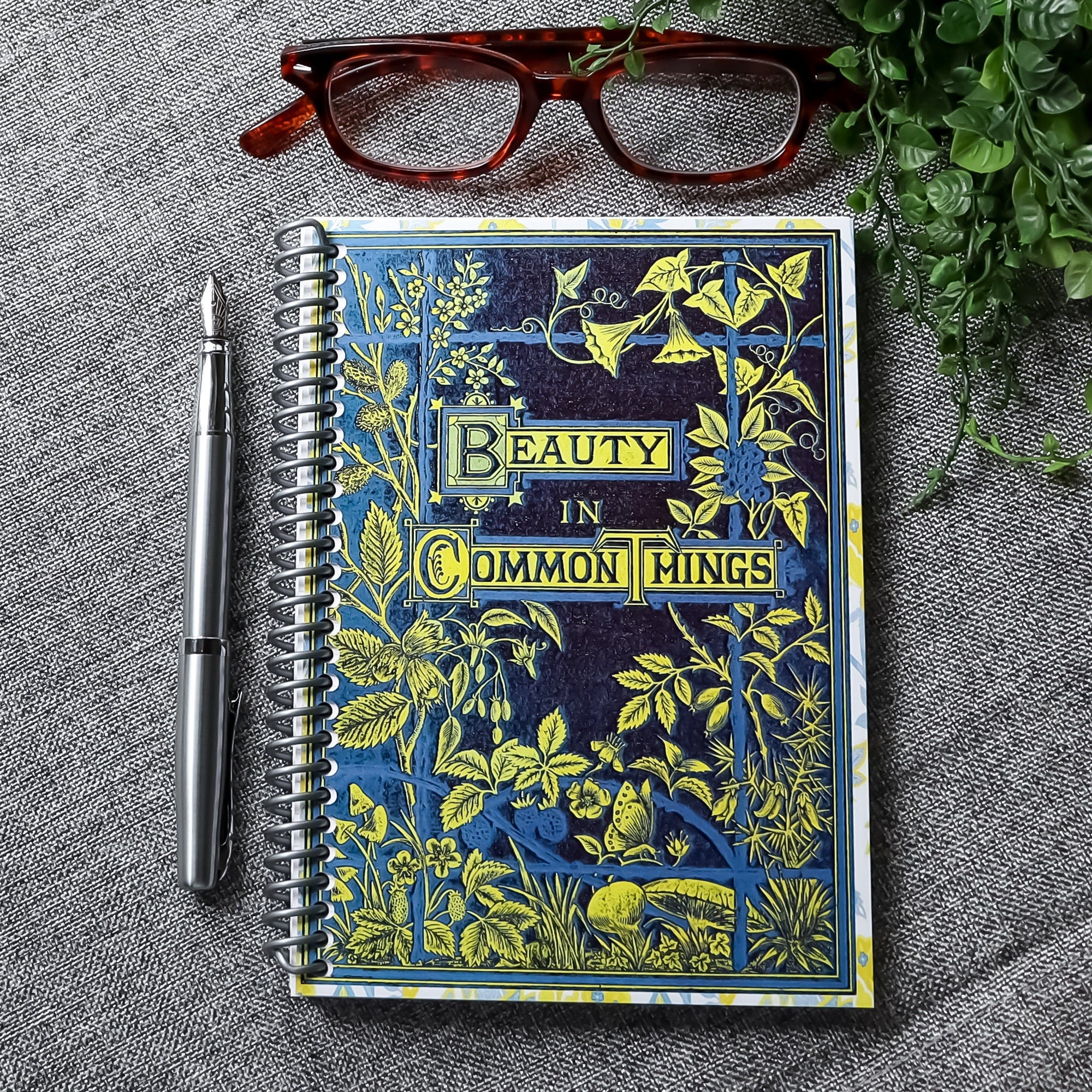 handmade travel notebook (5&quot; x 7&quot;) featuring a vintage book cover, Beauty in Common Things. Colors: navy blue, yellow, white, and light blue. Floral Patterns.