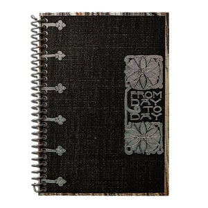 A travel-sized spiral notebook featuring a vintage book cover: FromDay To Day. Features a bold floral design. The colors are black, silver, gold and brown.